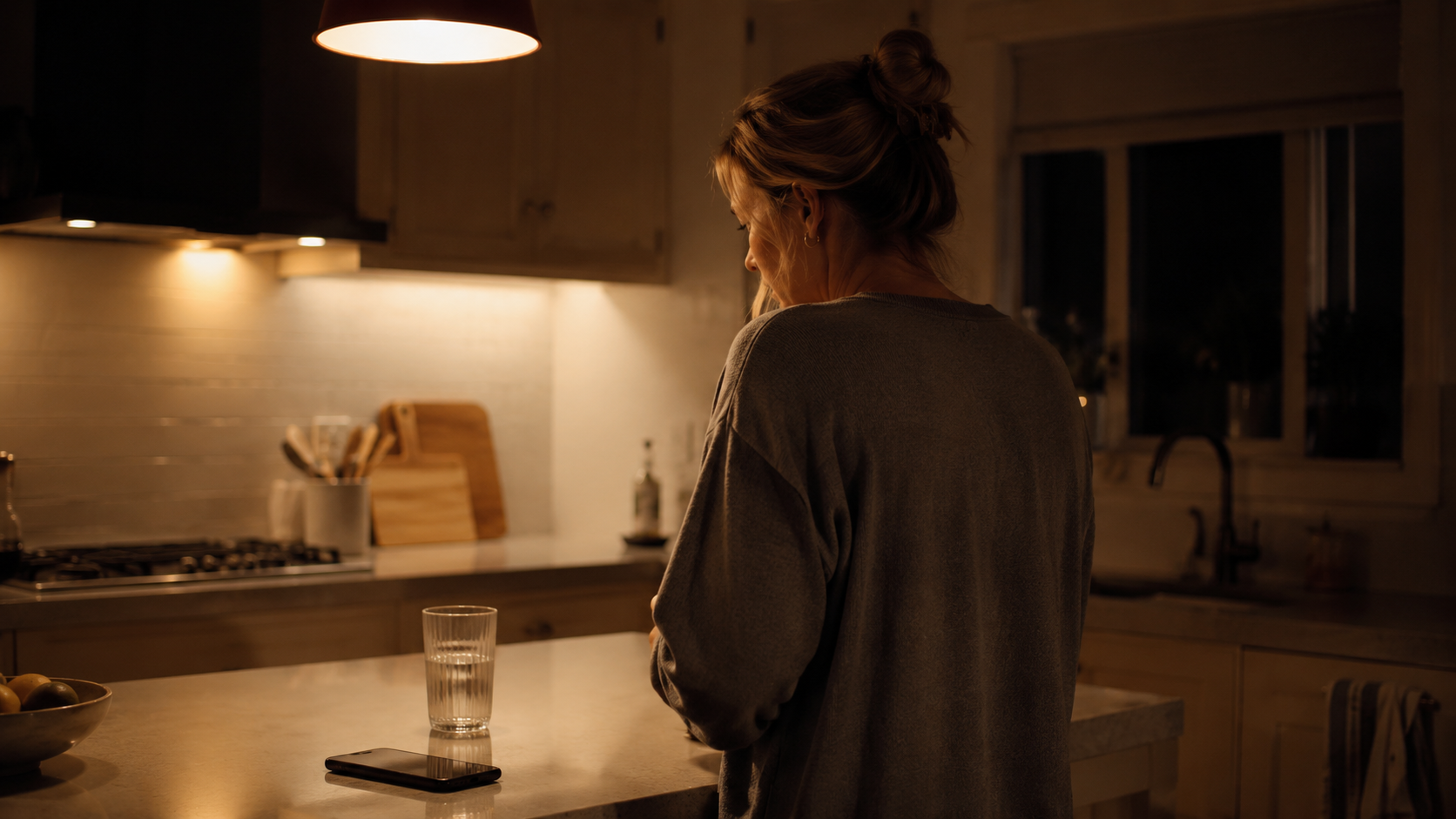 Person standing at a kitchen counter in evening light